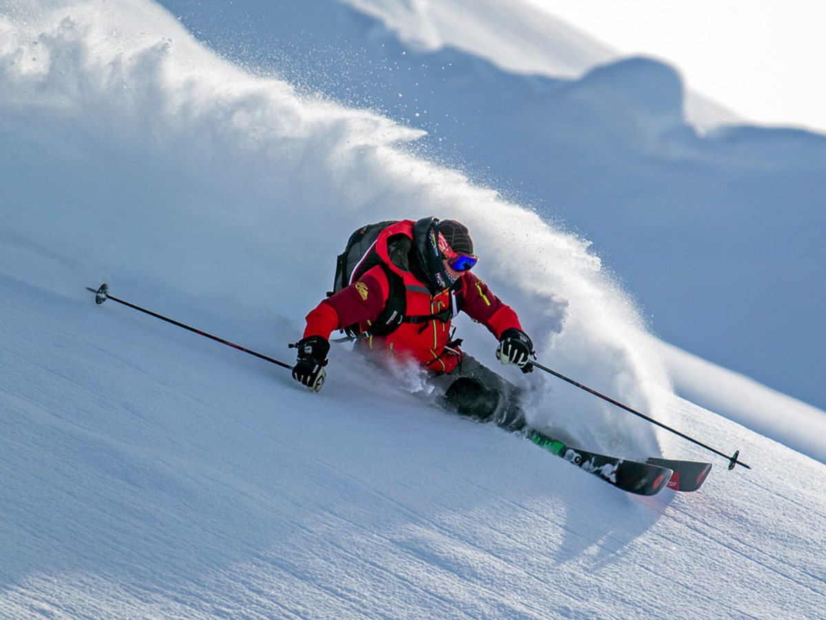 A skier carves down a mountain after being dropped by helicopter in the Tordrillo Mountains.