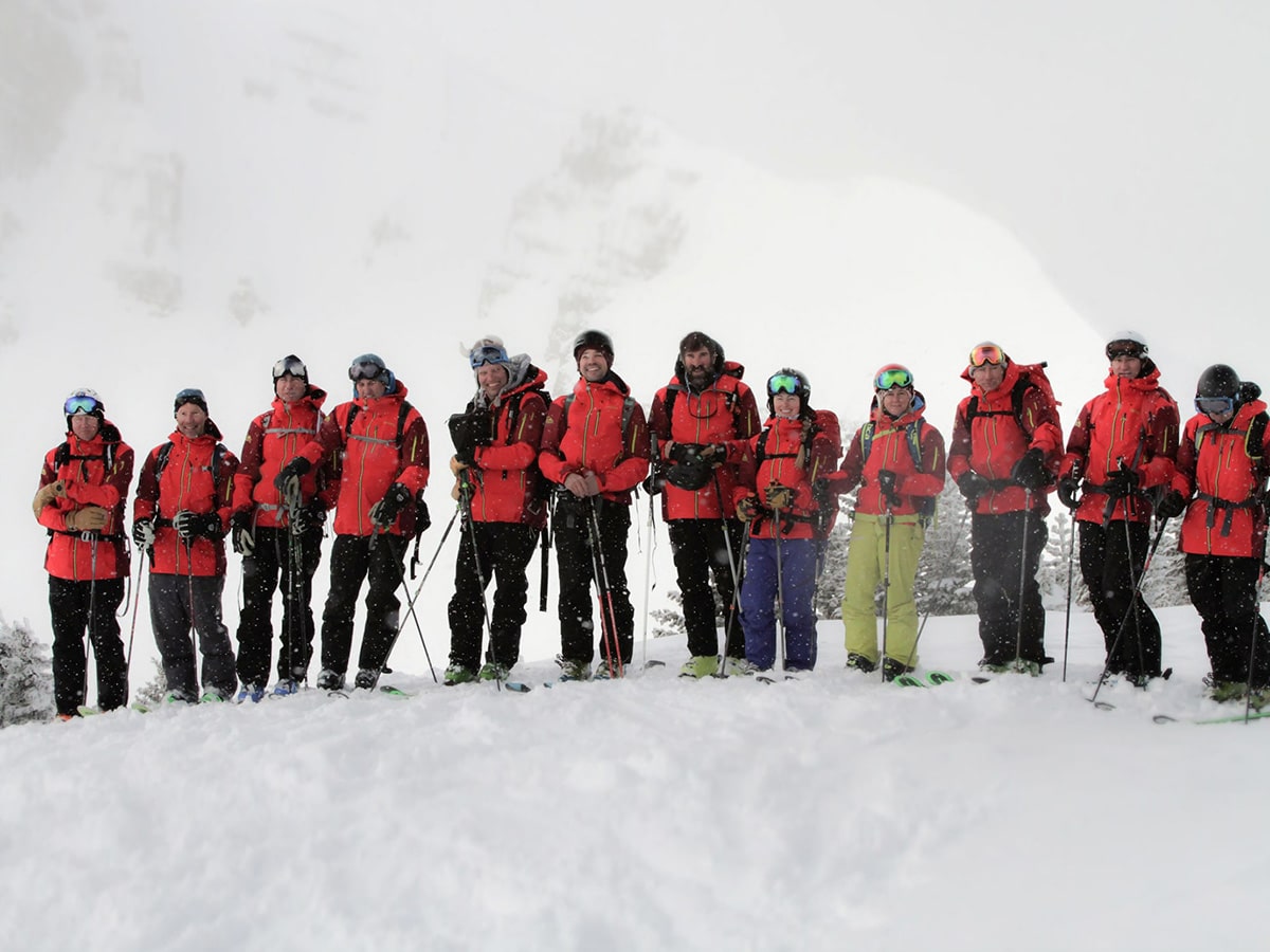 Group of skiers pose for a picture during a heli skiing excursion with Tordrillo Mountain Lodge.