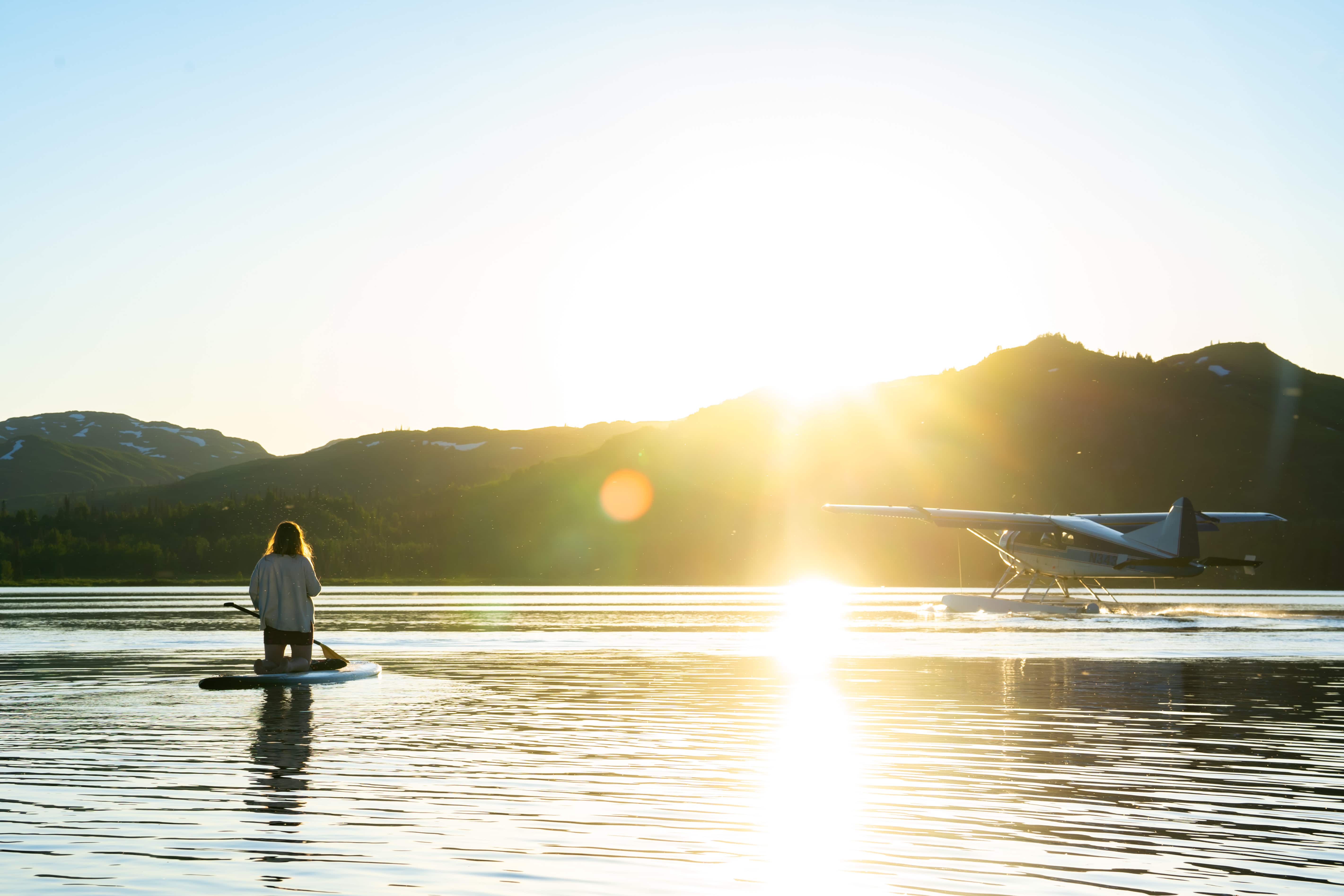 paddle boarding at sunset with an airplane on judd lake