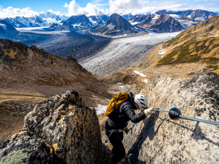 a woman climbs the via ferrata above the triumvirate glacier in the tordrillo mountains alaska