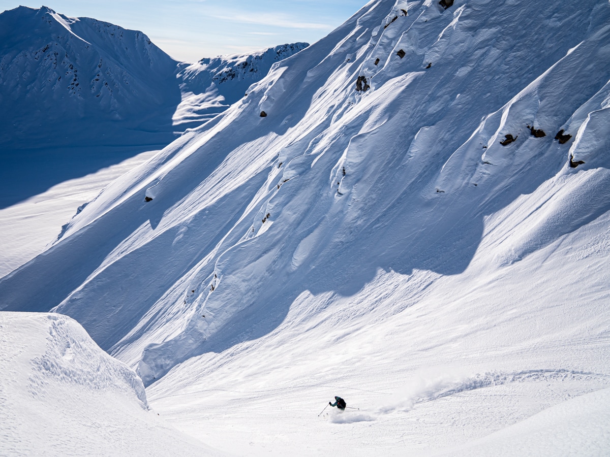 Heli skier navigates a snow-covered valley in Alaska.