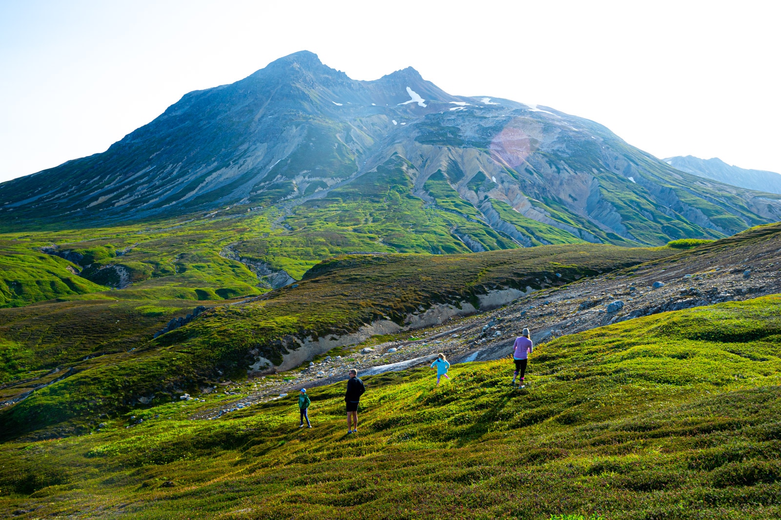 a family hikes across the tundra in the tordrillo mountains