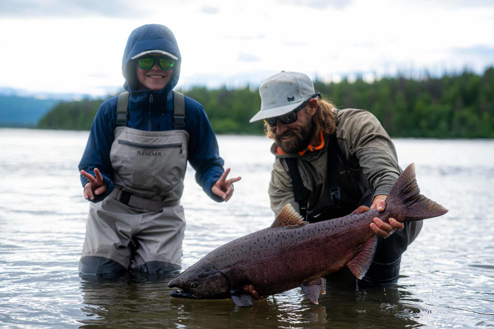 a kid catches a king salmon on the talchalitna river