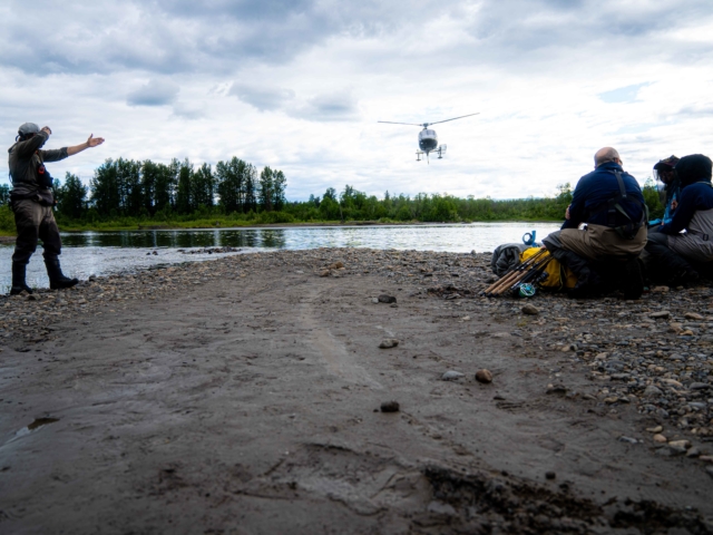 a helicopter comes to to pick up a group of fisherman