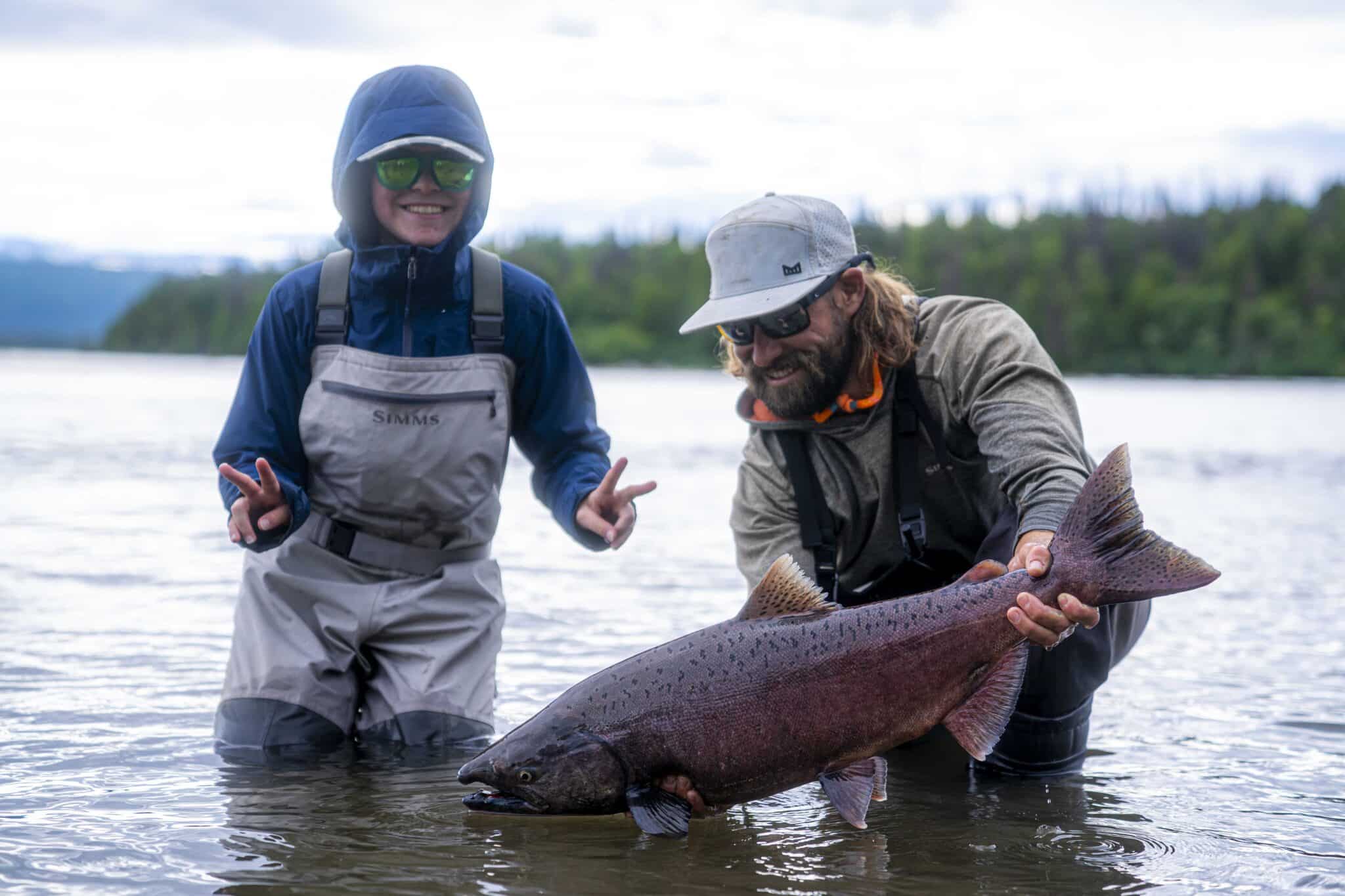 a kid catches a king salmon on the talchalitna river