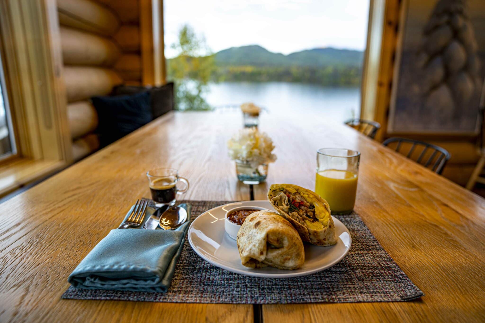 a breakfast burrito set at the table with coffee