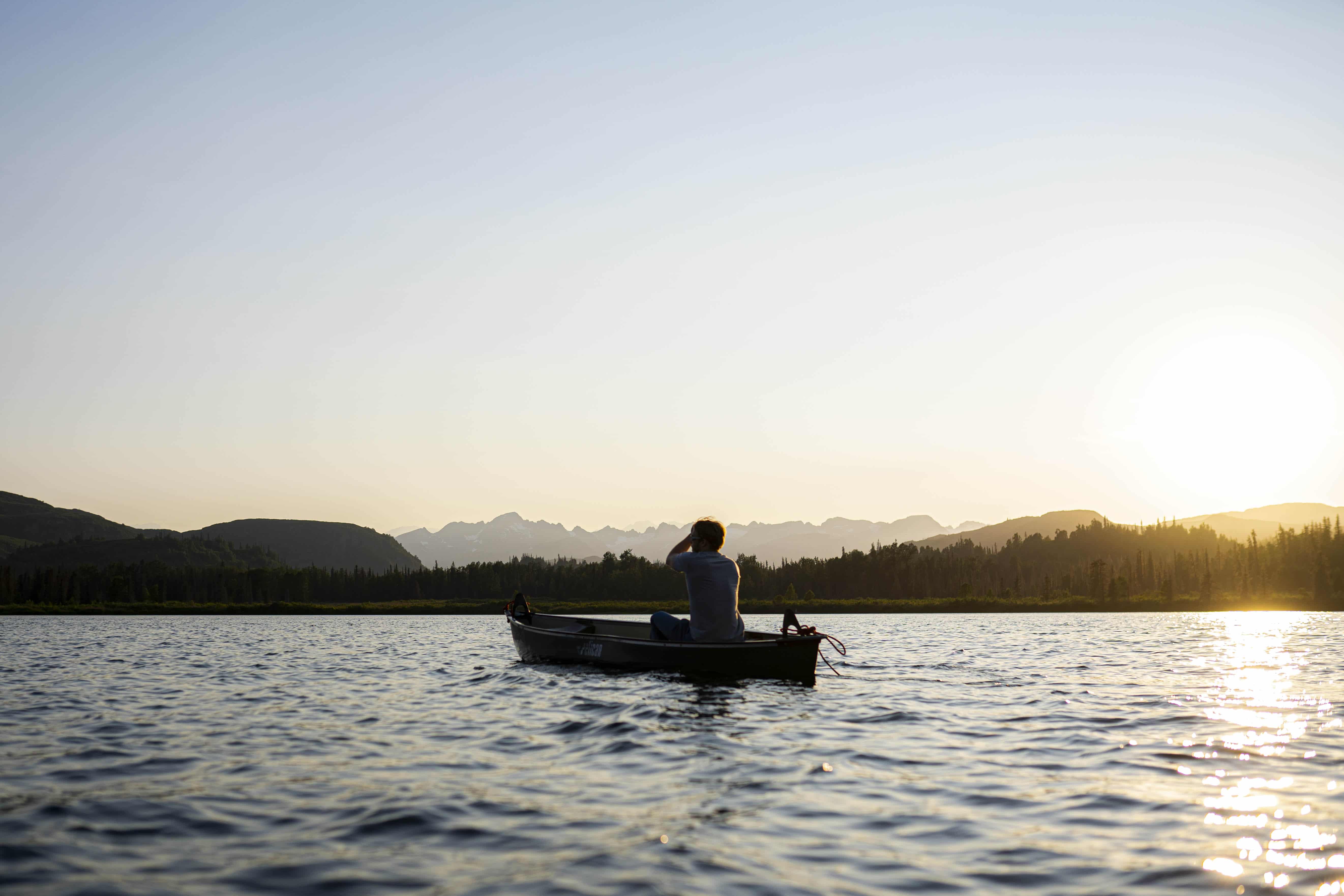 a man canoeing at sunset on judd lake