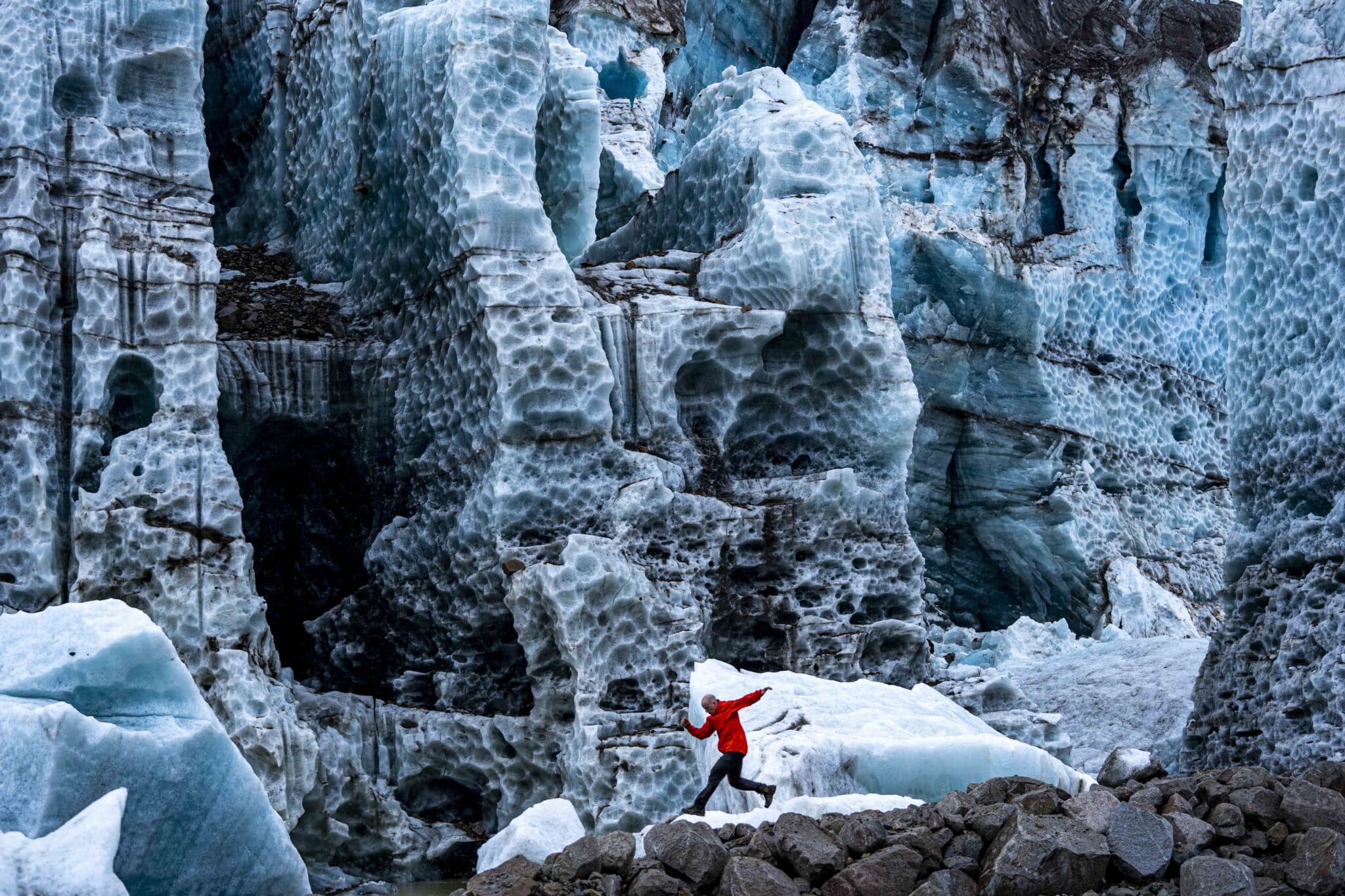 a man running in front of the triumvirate glacier in the tordrillo mountains